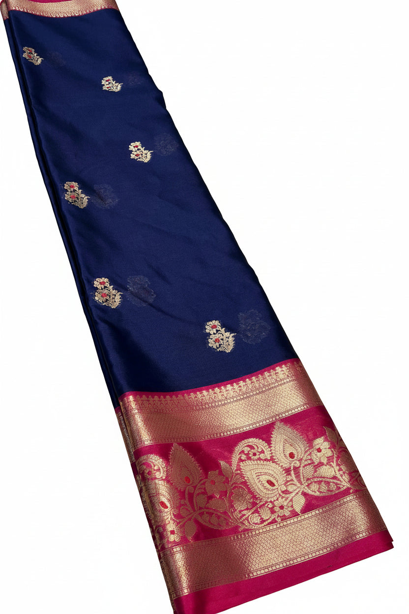 A navy blue silk saree with intricate gold zari embroidery and a vibrant pink and gold border,